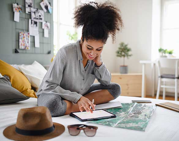 woman on bed planning a trip